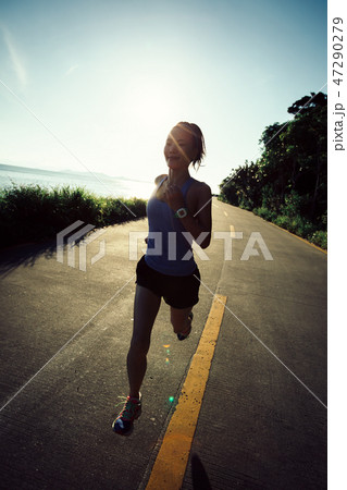 woman running on seaside trail in the morning woman running on seaside trail in the morning 47290279