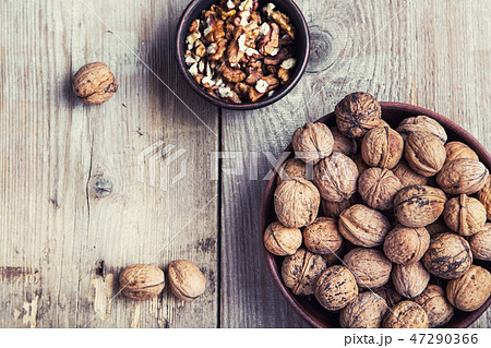 walnuts in a clay plate on a wooden background. walnuts in a clay plate on a wooden background. 47290366