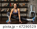 Young happy fitness woman doing leg stretching exercise 47290529