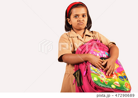 Little girl in school uniform holding school bag 47290689