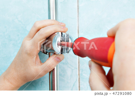 Worker hand adjusts angle adjustable bracket 47291080