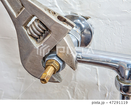 Plumber fixing water tap with leaking water 47291119