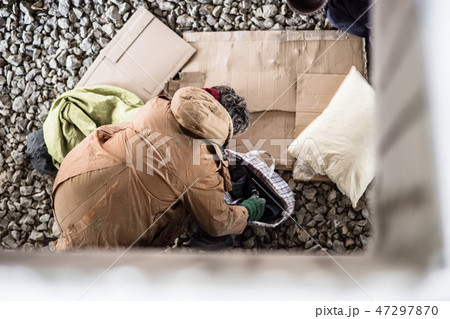 A top view of homeless beggar man with belongings outdoors in city. A top view of homeless beggar man with belongings outdoors in city. 47297870