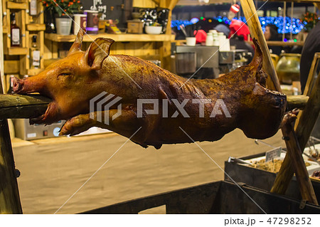 whole grilled pig on a spit in a restaurant 47298252