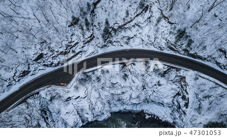 Tourist cars driving down asphalt road running along the emerald river 47301053