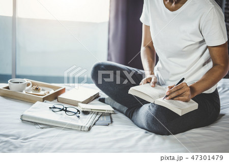 Young woman happiness on bedroom in enjoying reading books, news Young woman happiness on bedroom in enjoying reading books, news 47301479