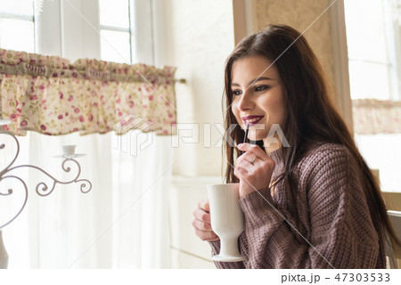 Young women enjoys fragrant latte and dreams Young women enjoys fragrant latte and dreams 47303533