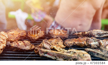 Friends frying the meat ribs and steaks, barbecue 47303584