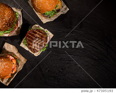 Top view of tasty burgers on wooden table. Top view of tasty burgers on wooden table. 47305193