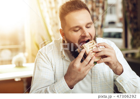 Portrait of man eating in cafe and enjoying food 47306292