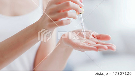 woman dropping moisturizer in hand 47307126