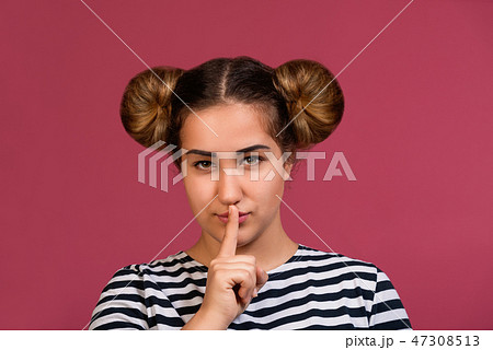Girl asking for silence with finger on lips shh Girl asking for silence with finger on lips shh 47308513