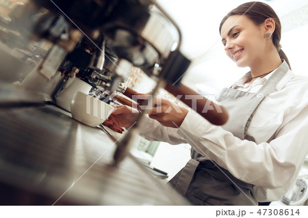 Beautiful young girl barista preparing coffee 47308614