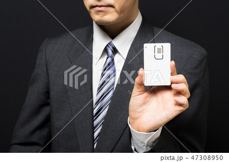 SIMカードを手に持つビジネスマン SIMカードを手に持つビジネスマン 47308950