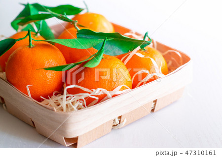 Tangerines with green leaves in a basket  47310161