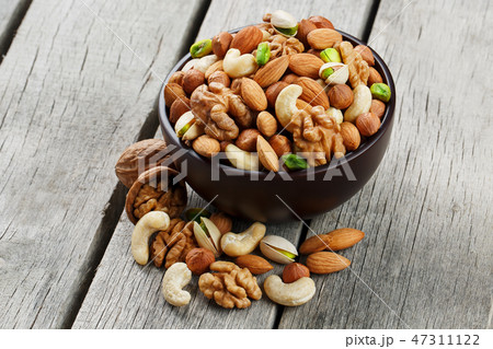 Wooden bowl with mixed nuts on a wooden gray 47311122