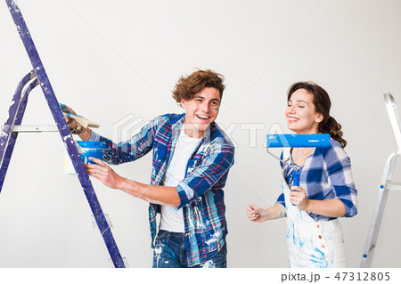 Repair, renovation and love couple concept - young family doing redecoration and painting walls 47312805