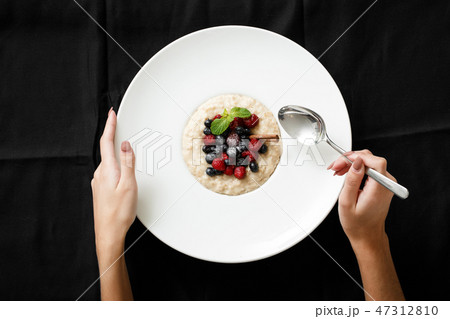 Top view of oatmeal with berries on white plate 47312810