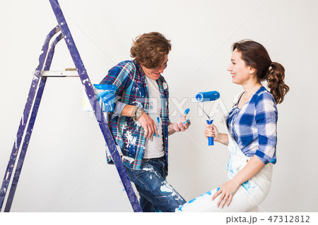 Renovation, redecoration and people concept - Portrait of couple stained with paint over white Renovation, redecoration and people concept - Portrait of couple stained with paint over white 47312812