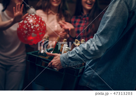 Man holding box with bottles of champagne at a party 47313203