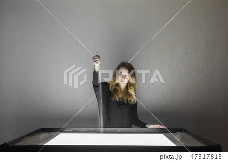 The woman draws on sand, sand animation, sand is pouring from his hands 47317813