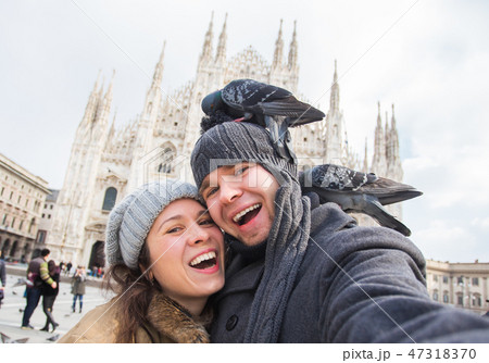 Travel, Italy and funny couple concept - Happy tourists taking a self portrait with pigeons in front 47318370