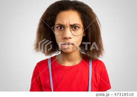 nervous young African American female bites lips nervous young African American female bites lips 47318510