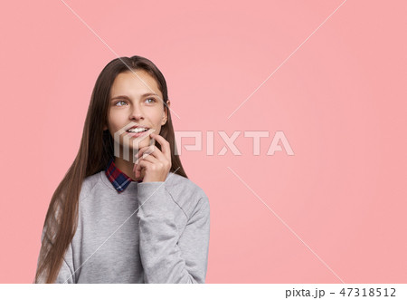 Pleased girl looks up with dreamful expression 47318512