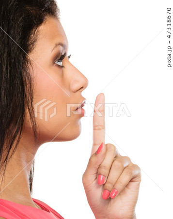 Woman with finger on lips showing silence gesture. 47318670