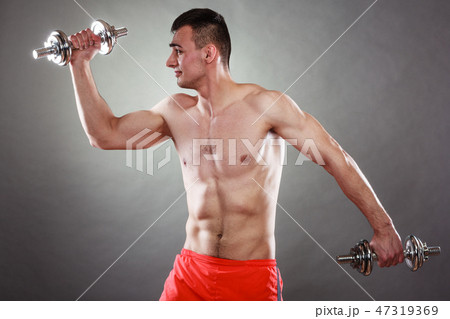 athletic man working with heavy dumbbells athletic man working with heavy dumbbells 47319369