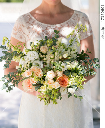 the bride is holding a rustic wedding bouquet of flowers and various herbs the bride is holding a rustic wedding bouquet of flowers and various herbs 47320601