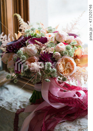 peach dark red wedding bouquet stands on the windowsill peach dark red wedding bouquet stands on the windowsill 47320746