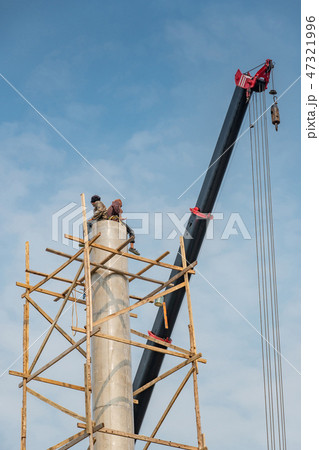 Workers sitting on the top of column at site 47321996
