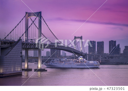 夕暮れのピンク色に輝くお台場湾でのびいなすクルーズ船の運航とその背景に浜松町と日の出の絶景 の写真素材