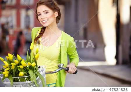 Woman wearing a spring skirt like vintage pin-up holding bicycle 47324328