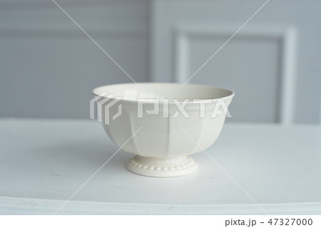 Elegant saucer on white table in large bright room. Elegant saucer on white table in large bright room. 47327000