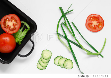 Scallions in center on a black oven dish healthy ingredient raw food concept 47327031