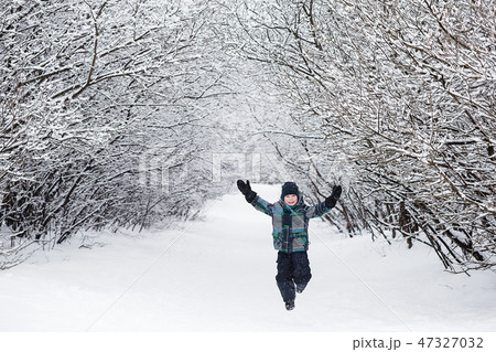 child enjoys the winter and playing with snow 47327032