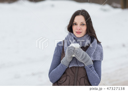 Woman holding hot drink outside 47327138