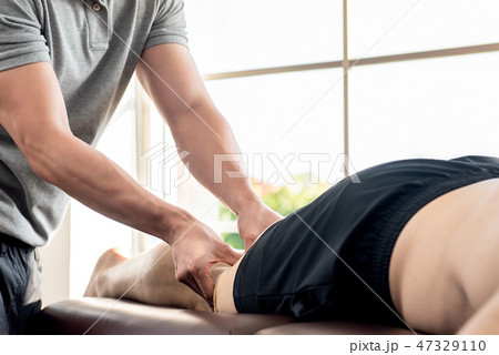 Male therapist giving leg massage to patient 47329110