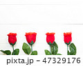 Present gift with red rose flower on wooden table 47329176