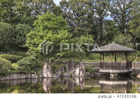目白庭園の池泉回遊式の池の周りに広がる松や紅葉の木を背景に水に反射する六角浮き見堂。 目白庭園の池泉回遊式の池の周りに広がる松や紅葉の木を背景に水に反射する六角浮き見堂。 47330196