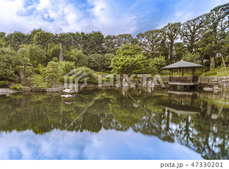 目白庭園の池泉回遊式の鯉が溢れる池の周りに広がる巨大な石、松の木、赤鳥庵と水に反射する六角浮き見堂。 目白庭園の池泉回遊式の鯉が溢れる池の周りに広がる巨大な石、松の木、赤鳥庵と水に反射する六角浮き見堂。 47330201