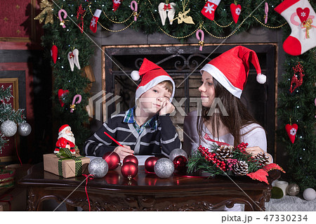 mother and son writing letter to Santa 47330234