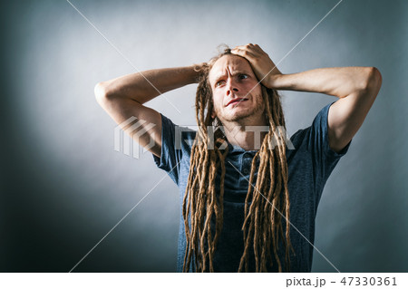 Young man feeling stressed on a solid background 47330361