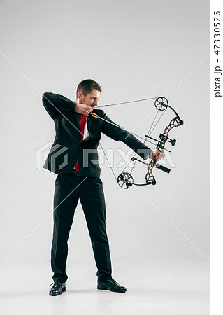 Businessman aiming at target with bow and arrow, isolated on white background Businessman aiming at target with bow and arrow, isolated on white background 47330526