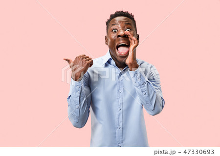 The young man whispering a secret behind her hand over pink background The young man whispering a secret behind her hand over pink background 47330693