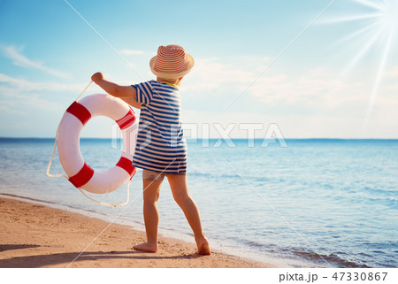 little boy playing at the beach in hat little boy playing at the beach in hat 47330867
