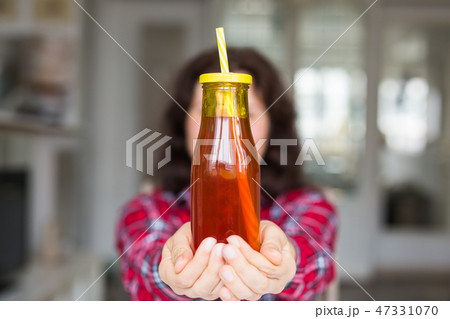 Drinks, diet and healthy lifestyle concept - woman giving you a bottle of natural juice Drinks, diet and healthy lifestyle concept - woman giving you a bottle of natural juice 47331070