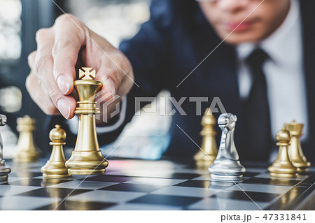 Businessman playing chess game reaching to plan strategy for suc Businessman playing chess game reaching to plan strategy for suc 47331841
